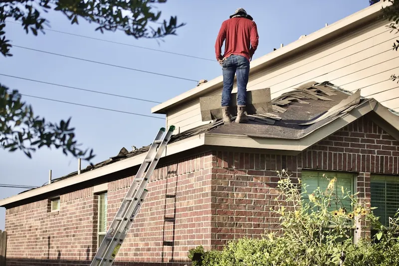 Professional roofer working on a residential roof in Levy